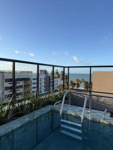 a swimming pool on the roof of a building at Aurea 310 in Tambaú