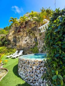 a pool in a yard with two chairs and a building at The Rock House Eco in San Andrés +141 photos