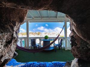 a hammock on a porch with a table and chairs at The Rock House Eco in San Andrés +114 photos