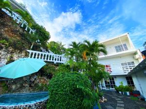 a house with an umbrella and a swimming pool at The Rock House Eco in San Andrés