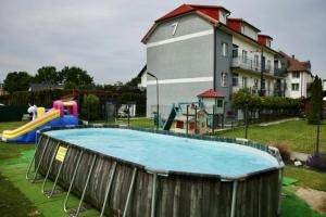 a playground with a pool in a yard with a house at siodemka in Darlowko