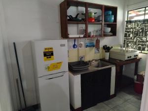 a kitchen with a white refrigerator and a sink at El Aguacatal in Panajachel