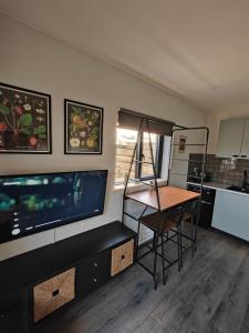 a living room with a flat screen tv and a table at Modern and peaceful, country retreat in Lahinch