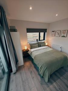 a bedroom with a large bed and a window at Modern and peaceful, country retreat in Lahinch