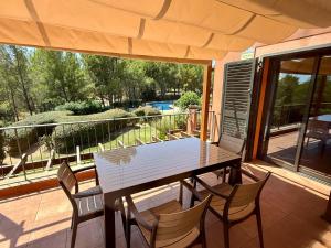einen Tisch und Stühle auf einer Terrasse mit Poolblick in der Unterkunft Charming Retreat in Bonmont in Bonmont Terres Noves