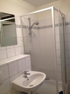 a white bathroom with a sink and a shower at Ferienwohnung Annelie in Zinnowitz