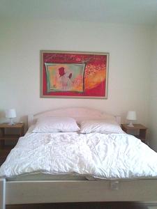 a bedroom with a bed with a painting above it at Ferienwohnung Julia in Zinnowitz