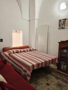 a bed with a striped blanket in a room at B&B Casa dolce casa in Cutrofiano