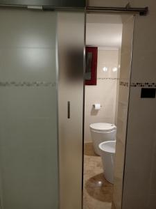 a bathroom with a toilet and a glass door at B&B Casa dolce casa in Cutrofiano