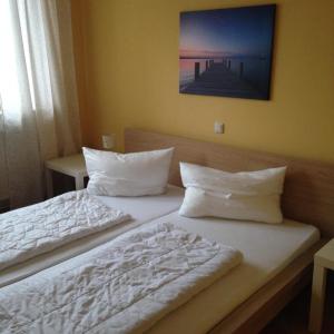 a bedroom with two beds with white blankets and pillows at Ferienhaus Emma in Zinnowitz