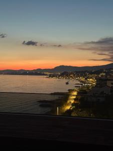 einen Sonnenuntergang über einem Wasserkörper mit einer Stadt in der Unterkunft Stella Maris Beach in Razvala
