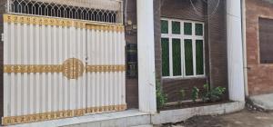 a white and gold gate and door on a house at Al IMRAN villa 2 bedroom apartment in Lahore