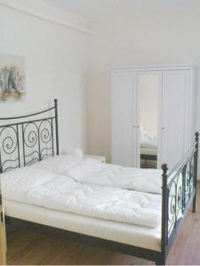 a bedroom with a bed with white sheets and a mirror at Ferienwohnung Michel in Ahlbeck