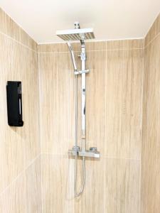a shower with a shower head in a bathroom at Tiny House moderne et cosy in Vernouillet