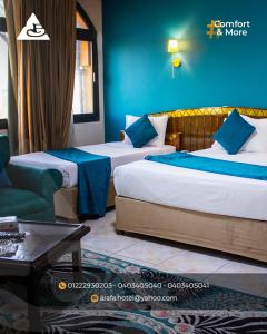 a hotel room with two beds and a couch at فندق عرفه الجديد in Tanta