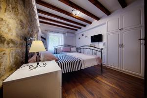 a bedroom with a bed and a table with a lamp at Riva Suite 1 in Komiža