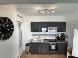 una cocina con un reloj grande en la pared en Charme Médiéval à Provins, en Provins