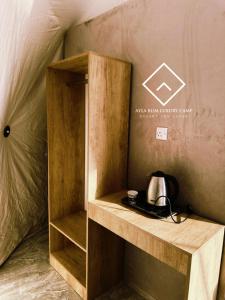 a small wooden shelf with a tea kettle on it at ALYA RUM LUXURY Camp in Wadi Rum