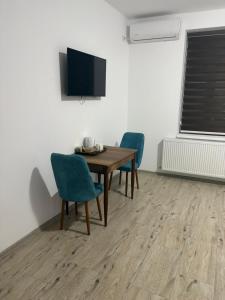 een eetkamer met een tafel, stoelen en een tv bij Casa Marko in Nădlac +22 foto's