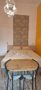 Ein Tisch mit einem Bett in einem Zimmer mit einem Kronleuchter in der Unterkunft SUITE Luxury Rooftop in Trapani