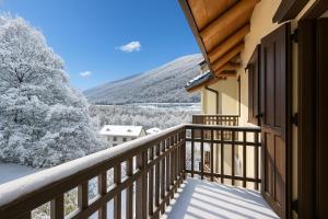 a balcony with a view of the snow covered trees at Relax In Pineta - Happy Rentals in Oulx +17 photos