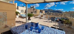 ein Tisch mit blauen Gläsern auf einem Balkon in der Unterkunft SUITE Luxury Rooftop in Trapani