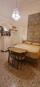 ein Schlafzimmer mit einem Bett mit einem Tisch und einem Kronleuchter in der Unterkunft SUITE Luxury Rooftop in Trapani