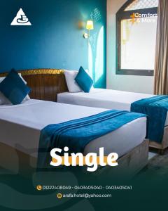 two beds in a hotel room with the words single at فندق عرفه الجديد in Tanta