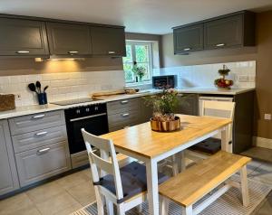 una cucina con un tavolo di legno e un tavolo e sedie di Hanger Farmhouse Hideaway a Totton and Eling