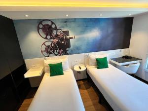 una habitación con dos camas con lavabo e inodoro en ibis Styles Montevideo Biarritz, en Montevideo