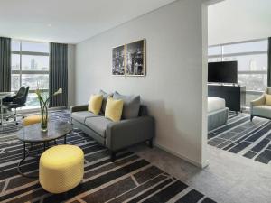 a living room with a couch and a table at Novotel Jakarta Cikini in Jakarta +96 photos