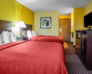 a hotel room with two beds and a television at AmericInn by Wyndham Mosinee Central Wisconsin Airport in Mosinee