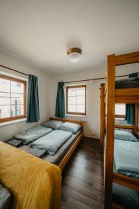 a bedroom with two bunk beds and two windows at Rezidence Rokytnice in Rokytnice nad Jizerou +118 photos