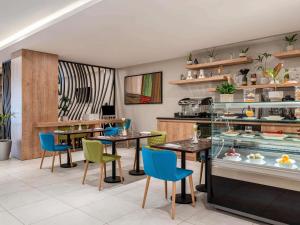 a restaurant with tables and chairs in a room at Adagio Aparthotel Jeddah Malik Road in Jeddah