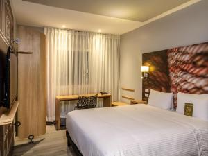 a hotel room with a bed and a television at ibis Quito in Quito