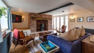 a living room with a couch and a fireplace at Ramsbury Cottage in Ramsbury