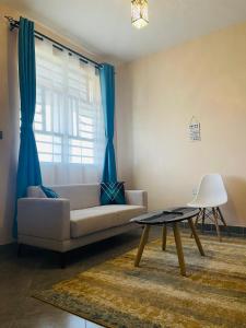 a living room with a couch and a table at A Oasis Taveta in Taveta +22 photos