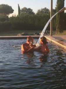 een man en een vrouw spelen in een zwembad bij Country House Le Torri di Porsenna in Petrignano sul Lago