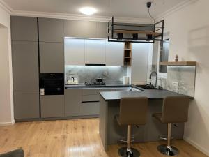 a kitchen with a counter and some chairs in it at Apartament in Ipotești in Ipoteşti +11 photos