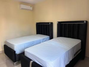 two beds sitting next to each other in a room at Mi refugio 2 in San Fernando de Monte Cristi