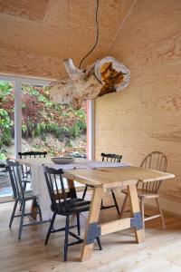 a dining room with a wooden table and chairs at 4 Strony Lasu in Gołaczów