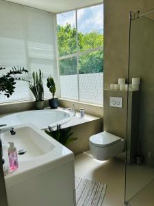 a bathroom with a sink and a toilet and a tub at Villa Vista in Wassenaar +44 photos