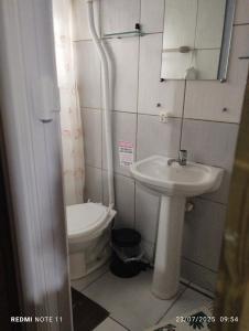 a bathroom with a toilet and a sink at Chalé da Sintia in Paranaguá