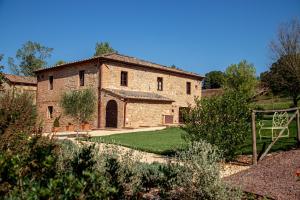 an external view of a stone house with a garden at Agriturismo La Frattina in Buonconvento