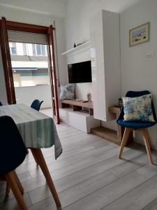 a living room with a table and chairs and a television at Seaview Allegra in Montesilvano