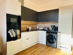 eine Küche mit weißen Schränken und einer Waschmaschine und einem Trockner in der Unterkunft Apartament Ratuszowy in Wałbrzych