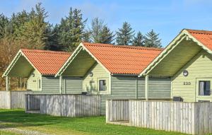 two houses with red roofs behind a fence at Amazing Home In Hanstholm With Private Swimming Pool, Can Be Inside Or Outside in Pugdal