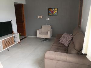 a living room with a couch and a chair at Casa com visto para o Cristo e cidade in Encantado