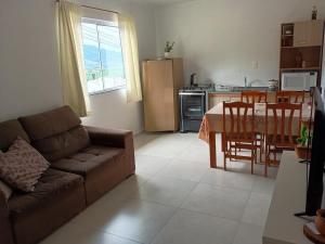 a living room with a couch and a table and a kitchen at Casa com visto para o Cristo e cidade in Encantado