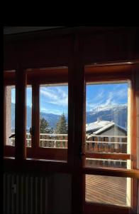 ein Fenster mit Blick auf die Berge in der Unterkunft Casa vacanze la primula erro in Sauze d'Oulx